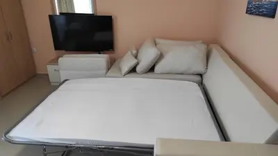 a white couch in a room with a flat screen tv at Double Peach Apartment in Sveti Vlas