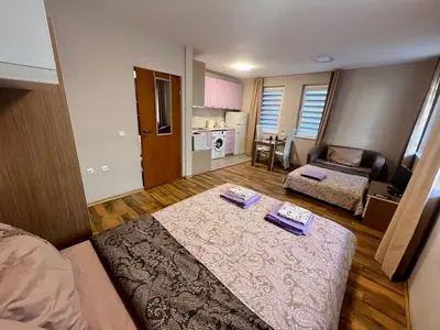 a bedroom with a bed and a living room at Cozy One-Bedroom Apartment near Burgas Sea Garden in Burgas City