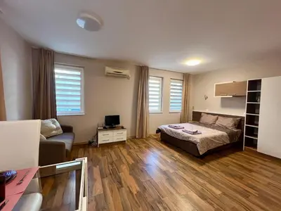 a bedroom with a bed and a couch and a desk at Cozy One-Bedroom Apartment near Burgas Sea Garden in Burgas City