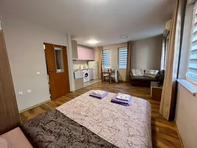 a living room with a bed and a kitchen at Cozy One-Bedroom Apartment near Burgas Sea Garden in Burgas City