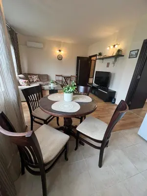 a living room with a wooden table and chairs at Apartment Chocolate Ravda in Ravda