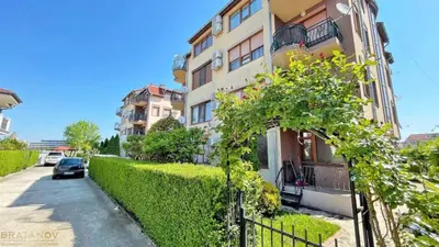 a building with a hedge next to a street at Apartment Chocolate Ravda in Ravda