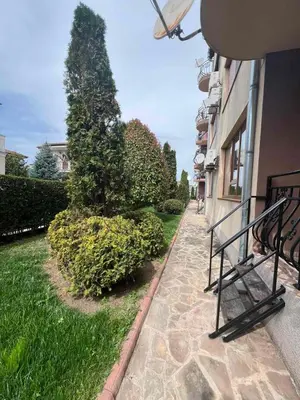 a sidewalk with a bench next to a building at Apartment Chocolate Ravda in Ravda