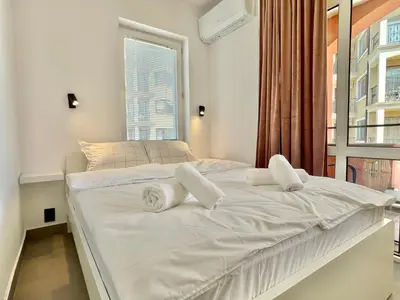 a white bed in a room with a window at Carina Beach - Private apartment - BSR - 1 in Sunny Beach
