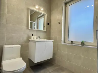 a bathroom with a toilet and a sink and a window at Carina Beach - Private apartment - BSR - 1 in Sunny Beach