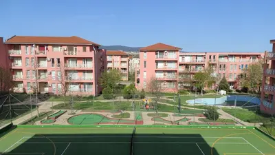 a tennis court in front of some apartment buildings at Double Cherry Apartment in Sunny Beach