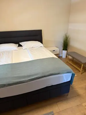 a bedroom with a bed and a bench and a plant at Apartment Maria in Burgas City
