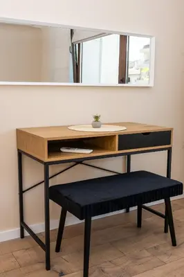 a desk with a stool in front of a mirror at Apartment Maria in Burgas City