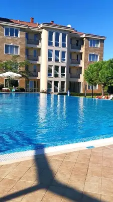a large blue swimming pool in front of a building at Студио Черноморски залив Атия Резорт in Chernomorets