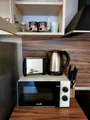 a microwave oven with a coffee pot on top of it at Студио Черноморски залив Атия Резорт in Chernomorets