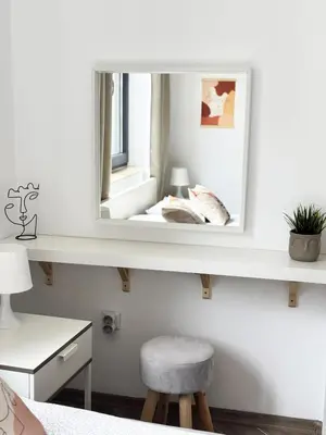 a mirror on a wall with a stool in a room at Urban Oasis in Varna City