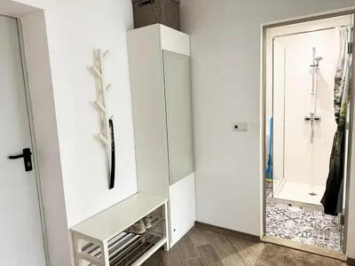 a white closet with a mirror next to a door at Urban Oasis in Varna City