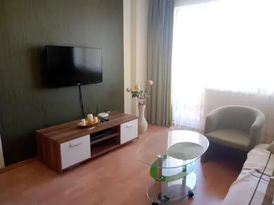 a living room with a tv and a couch and a table at Splendid sunny seasons in Byala