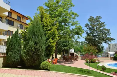 a garden with a pool and a table and chairs at Splendid sunny seasons in Byala