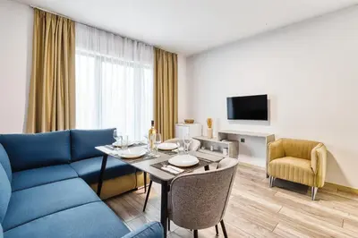 a living room with a table and a blue couch at Marina Bay Apartments Kraymorie in Burgas City