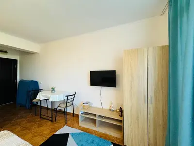 a living room with a table and a tv on a wall at SAINT ELENA APART COMPLEX 47 Studio in Sunny Beach