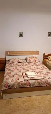 a bedroom with a bed with a phone on it at Family House Victoria' Garden in Primorsko