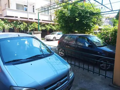 two cars are parked next to a fence at Family House Victoria' Garden in Primorsko