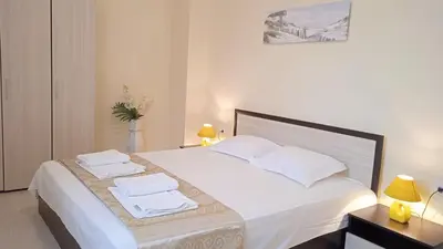 a bedroom with a large white bed with towels on it at Апартамент в непосредствена близост до плажа III in Burgas City