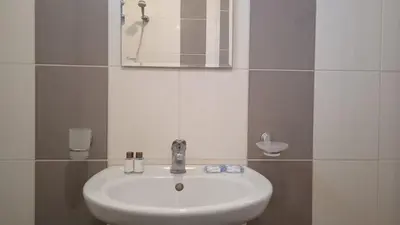 a white sink in a bathroom with a mirror at Апартамент в непосредствена близост до плажа III in Burgas City