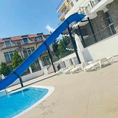a blue water slide in front of a building at Grand Villa Perle in Sveti Vlas