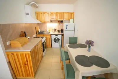 a small kitchen with a table and a refrigerator at Spacious 2BD Apartment - Walk to City Center and free Parking by Flat Mаnager in Burgas City