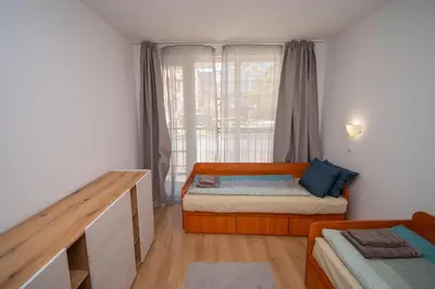 a small bedroom with a bed and a window at Spacious 2BD Apartment - Walk to City Center and free Parking by Flat Mаnager in Burgas City