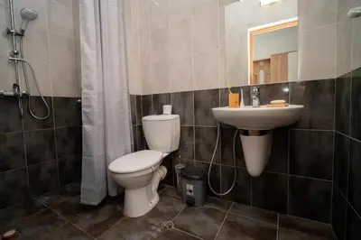 a bathroom with a toilet and a sink at Spacious 2BD Apartment - Walk to City Center and free Parking by Flat Mаnager in Burgas City