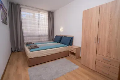 a small bedroom with a bed and a window at Spacious 2BD Apartment - Walk to City Center and free Parking by Flat Mаnager in Burgas City
