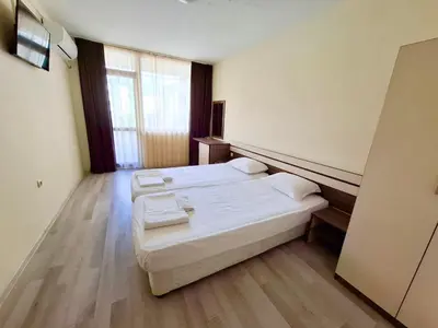 a room with two beds and a large window at Stamopolu Apartments in Primorsko