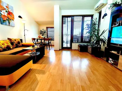 a living room with a couch and a flat screen tv at Апартамент Цар Самуил in Burgas City