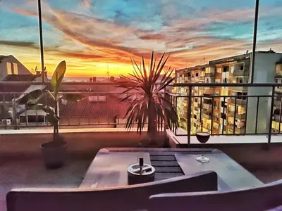 a balcony with a table and a view of a sunset at Апартамент Цар Самуил in Burgas City