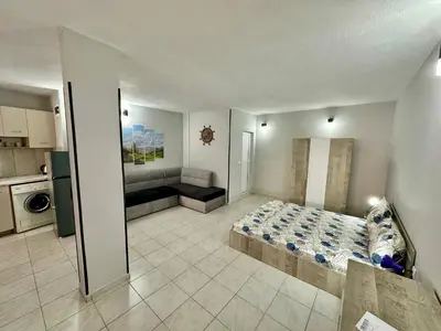 a large bedroom with a bed and a kitchen at Студио Боряна in Pomorie