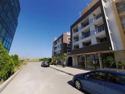 a blue car parked on a street next to a building at APART-HOTEL Stamopolu Lux с изглед към морето in Primorsko