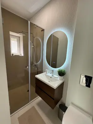 a bathroom with a sink and a shower and a mirror at Heart of Varna, Close to the Sea in Varna City