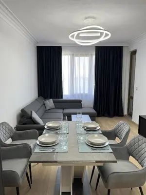 a living room with a table with chairs and a couch at Lago Mare Apartment in Pomorie