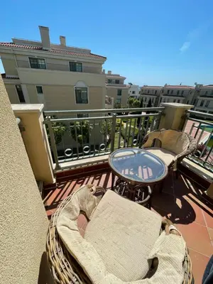 a balcony with a table and chairs on a building at Flores Garden Pool & Sea View Studio in Chernomorets