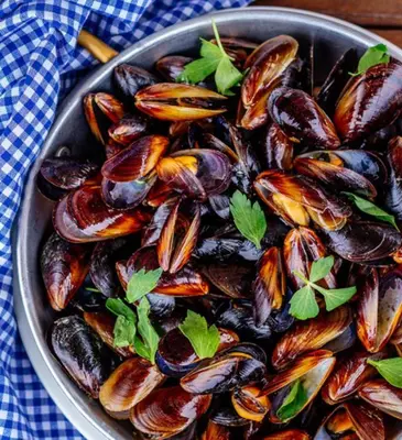 a bowl filled with mussels on top of a table at Flores Garden Pool & Sea View Studio in Chernomorets