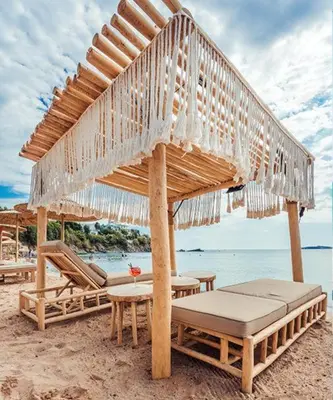 a pavilion with chairs and tables on a beach at Flores Garden Pool & Sea View Studio in Chernomorets