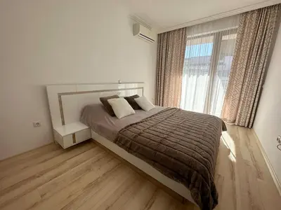 a bedroom with a bed and a large window at Apartment in the complex Olymp in Sveti Vlas