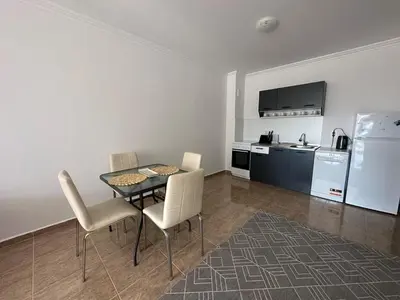 a dining room with a table and chairs and a kitchen at Apartment in the complex Olymp in Sveti Vlas