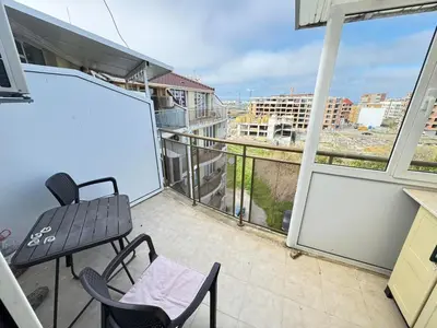 a balcony with two chairs and a chalkboard on a building at Pomorian Pearl in Pomorie