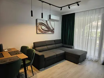 a living room with a couch and a table at 3 комнатные новые апартаменты у моря in Sveti Vlas