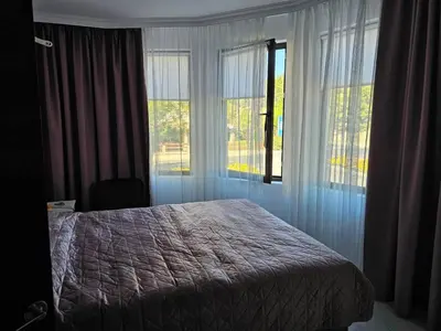 a bedroom with a bed and two large windows at 3 комнатные новые апартаменты у моря in Sveti Vlas