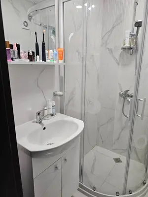 a white bathroom with a sink and a shower at 3 комнатные новые апартаменты у моря in Sveti Vlas