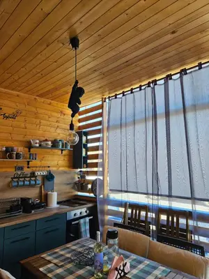 a kitchen with wooden ceilings and a table in a kitchen at Бунгало HAKUNA MATATA, Къмпинг Созопол Еко, плаж Градина in Sozopol