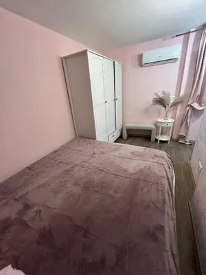 a pink bedroom with a bed and a cabinet at Family in Varna City