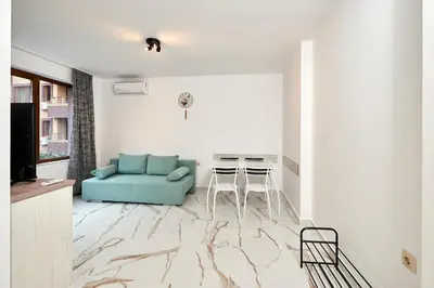 a living room with a blue couch and a table at АПАРТАМЕНТИ Радина in Pomorie