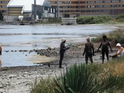 a group of people in wet suits standing on the beach at АПАРТАМЕНТИ Радина in Pomorie