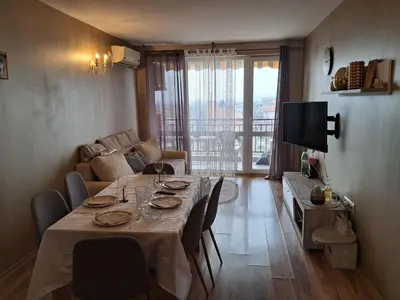 a living room with a table with chairs and a television at Apartament in Aheloy in Aheloy